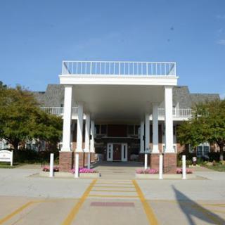 A modern architectural entrance with a spacious overhang and columns.