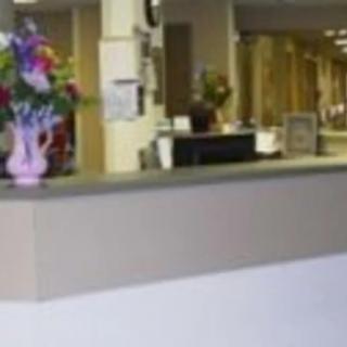 A reception desk with a vase of flowers in an office setting.