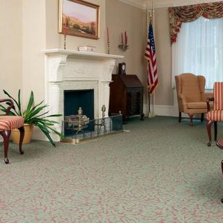 A traditional living room with a fireplace, American flag, and classic furniture.