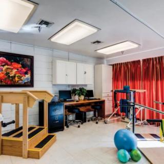A well-equipped physical therapy room with exercise balls, a set of stairs for rehabilitation, and other therapy equipment.