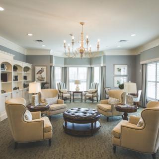 A spacious living room with elegant furniture and a chandelier.