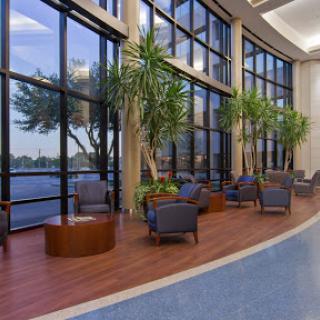 A cozy lounge area with comfortable seating and large windows overlooking a serene water view.
