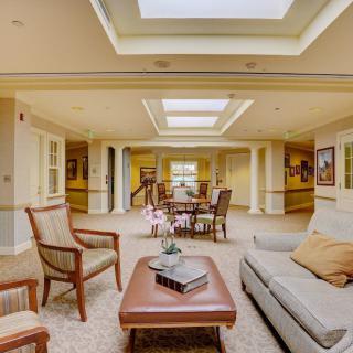 A spacious and elegantly designed living room featuring comfortable seating, a central coffee table, and natural light from skylights.