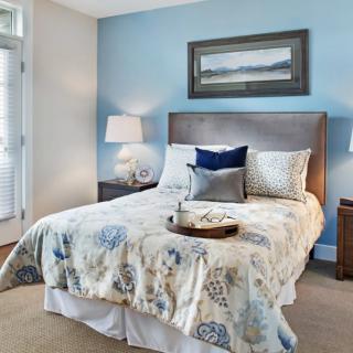 A cozy bedroom with a neatly made bed, soft lighting, and tasteful decor.