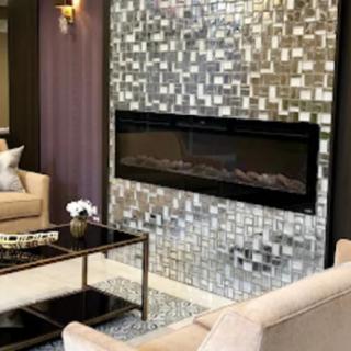 A modern living room with a sleek fireplace and mosaic tile wall.