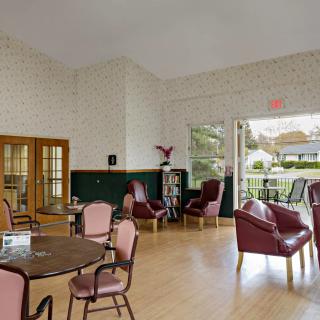 A bright and cozy lounge area with various seating options and large windows letting in natural light.