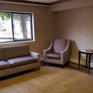 A cozy living room featuring a sofa, an armchair, and a small side table by the window.
