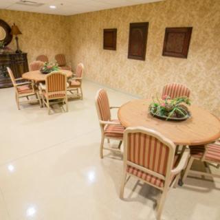 A cozy dining area with round tables and chairs, decorated with plants and wall art.