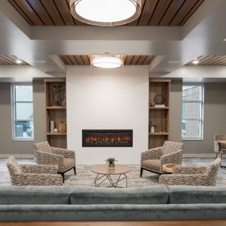 A modern living room with comfortable seating and a fireplace.