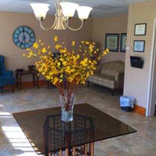 A cozy living room with a decorative vase of yellow flowers on a table and elegant furniture.