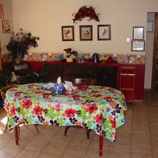 A dining room with a colorful floral-patterned tablecloth on the table.