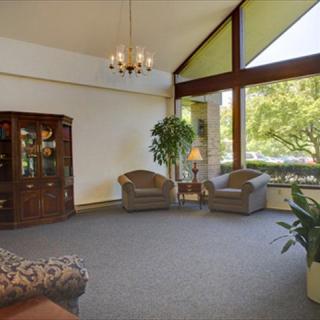 A spacious living room with large windows, comfortable seating, and natural light.