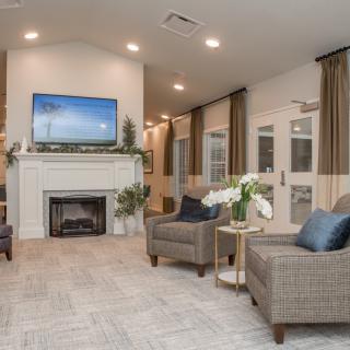 A modern living room featuring a fireplace, comfortable seating, and a large television.