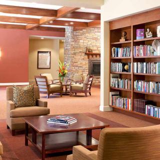 Cozy library with comfortable seating and shelves filled with books.