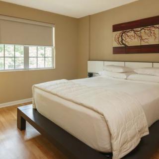 A minimalistic bedroom with a large bed and a window.