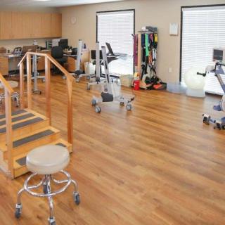 A physical therapy room equipped with various rehabilitation and exercise equipment.