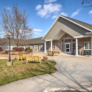 A well-maintained building with an outdoor seating area and garden under a clear blue sky.
