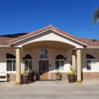 A residential building with a decorative entrance and columns under a clear blue sky.