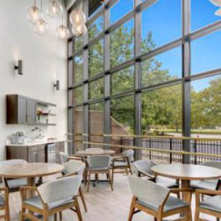 A modern cafe interior with large windows allowing natural light to flood the space.