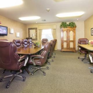 A well-lit conference room with leather chairs around a large table, ready for a meeting.