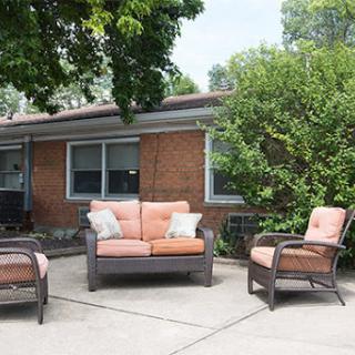 A cozy outdoor seating arrangement featuring a sofa and two armchairs, perfect for relaxation in a residential patio.