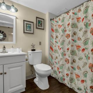 A neatly organized bathroom with a floral shower curtain and modern fixtures.