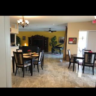 Spacious and elegantly decorated living and dining area with a piano.