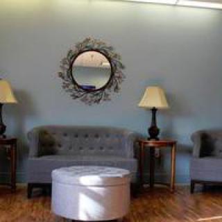 A cozy living room setup with sofas, lamps, and a decorative mirror.