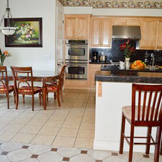 A modern kitchen and dining area featuring wooden cabinets, stainless steel appliances, and a stylish dining table with chairs.