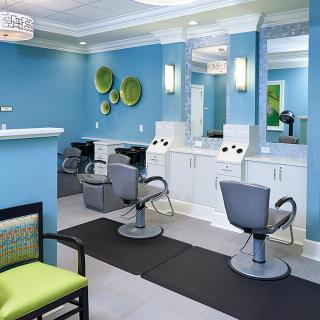 A modern hair salon with blue walls, featuring styling chairs and a waiting area.