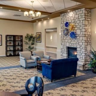 A cozy living room with comfortable seating and a stone fireplace.