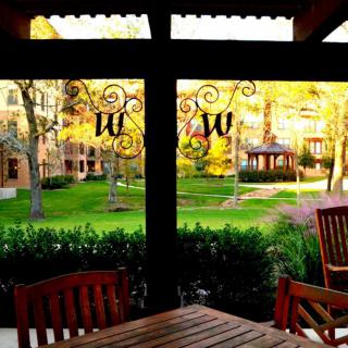 A cozy patio overlooking a lush garden with a gazebo in the distance.