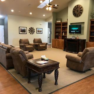 A cozy living room featuring comfortable recliners, a coffee table, and a television, perfect for relaxation and gatherings.