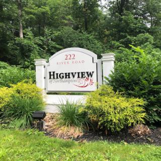 A welcoming sign for Highview surrounded by lush greenery.