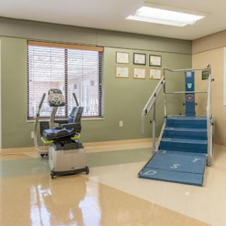 A well-equipped rehabilitation therapy room featuring exercise equipment and a ramp for accessibility.