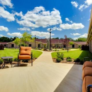 A beautiful courtyard with seating areas and a landscaped garden under a bright blue sky.