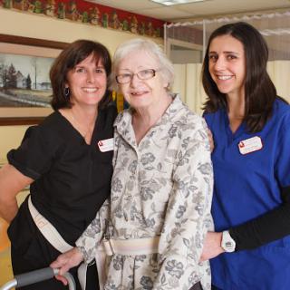 Caring moments in elderly support, showcasing dedicated nursing staff with a resident.
