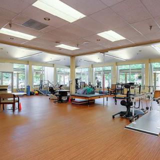 An empty physical therapy and rehabilitation center with various exercise equipment.