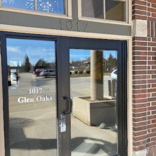 The entrance of a commercial building featuring a glass door and visible signage.