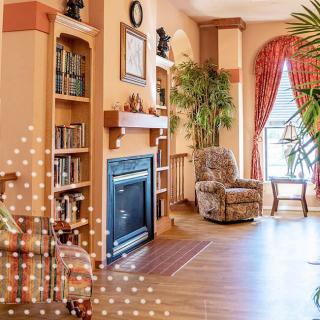 Cozy living room with a fireplace, bookshelves, and an armchair.