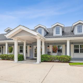 A picturesque, single-story house with a charming front porch and manicured shrubs.