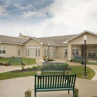 A courtyard with benches and landscaped pathways in front of a building.