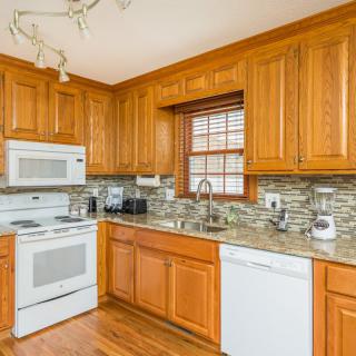 A modern kitchen with wooden cabinets and standard appliances.