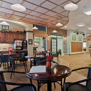 A cozy cafe interior with seating areas and warm lighting.