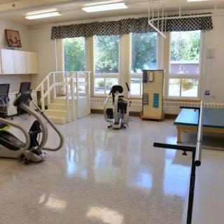 A bright and spacious rehabilitation therapy room equipped with various exercise machines.