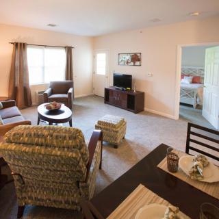 A cozy living room with comfortable seating, a TV, and an adjacent dining area.