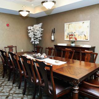 A well-furnished dining room featuring a large wooden table surrounded by chairs, complemented by decorative elements.