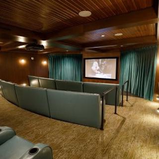A cozy home theater with tiered seating and a large screen for optimal viewing.