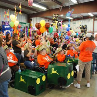A lively gathering filled with excitement, featuring participants in bright orange shirts and colorful decorations.