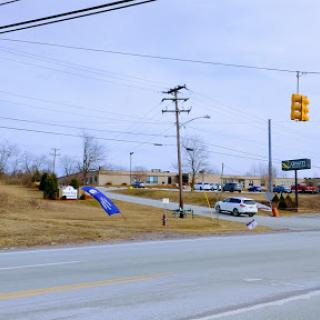 A view of a road with traffic lights and vehicles in a commercial area during winter.